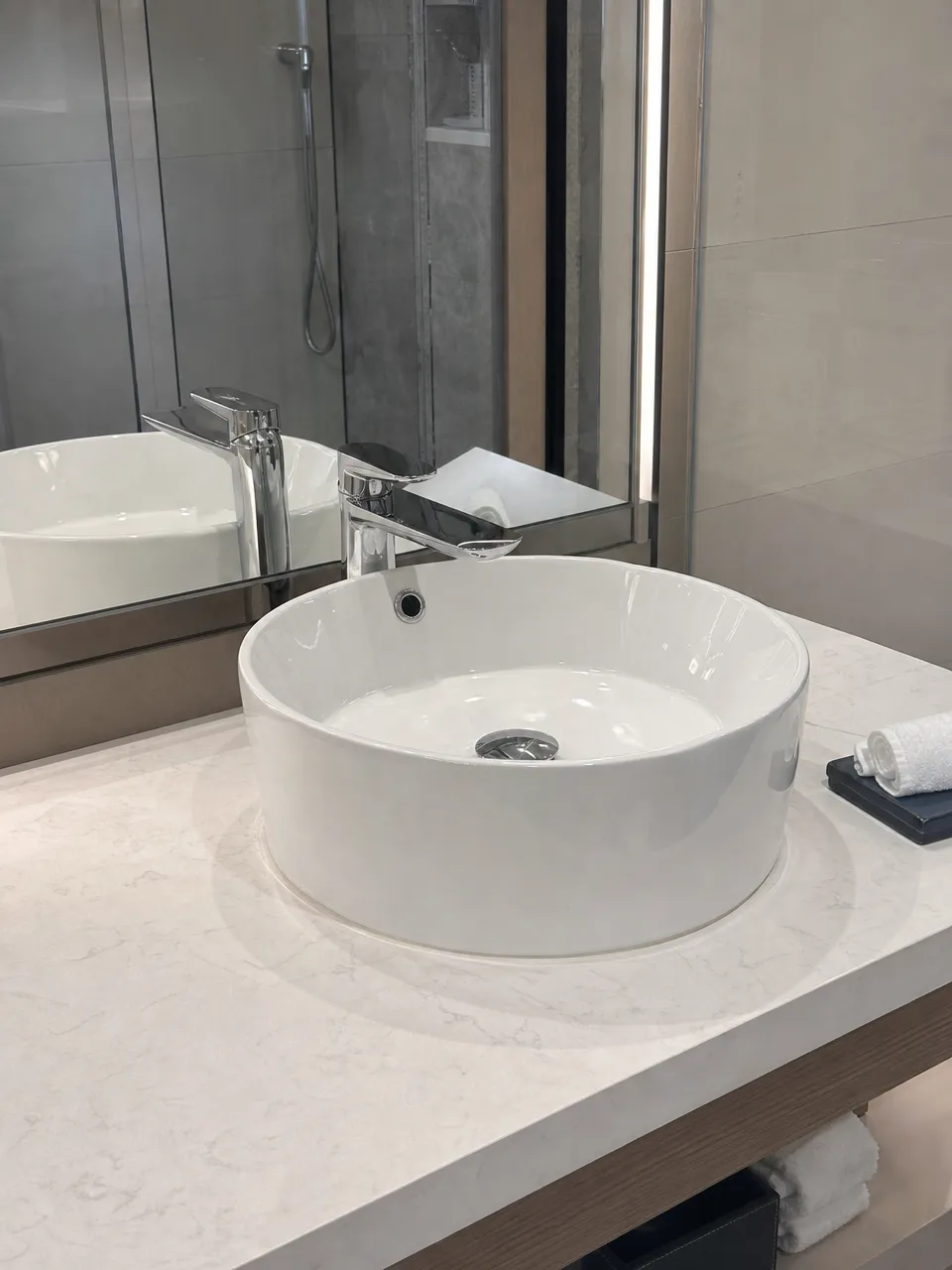 Low profile faucet installed on vessel sink in hotel bathroom renovation project