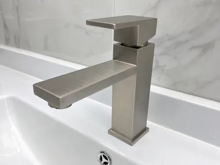 Brushed nickel finish on modern bathroom faucet with linear brush stroke on flat face