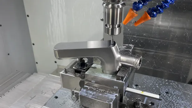 CNC finishing pass on flat spout face of modern bathroom faucet body