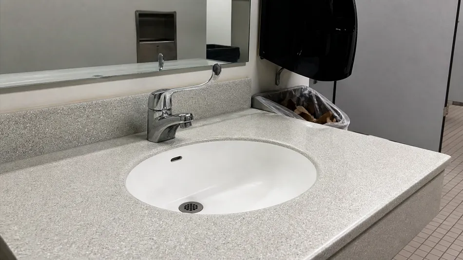 ADA-compliant side handle faucet in public institutional building restroom