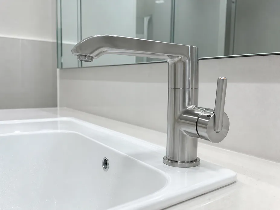 Side-mounted lever position on bathroom faucet demonstrating ADA-compliant single-hand operation