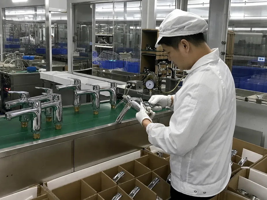 Quality control inspection on the Foshan production floor for side handle bathroom faucets