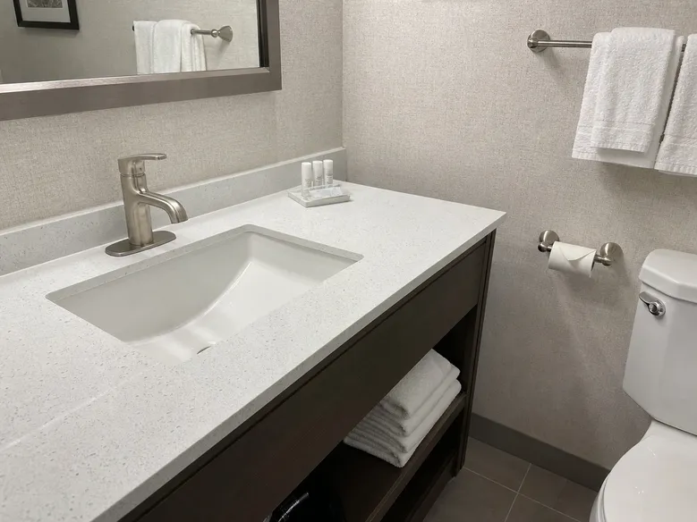 Single handle bathroom faucet installed in hotel guest bathroom with matching finish fixtures