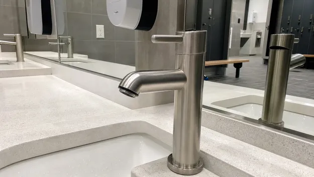 Brushed stainless steel faucet finish durability in high-traffic gym and school restroom