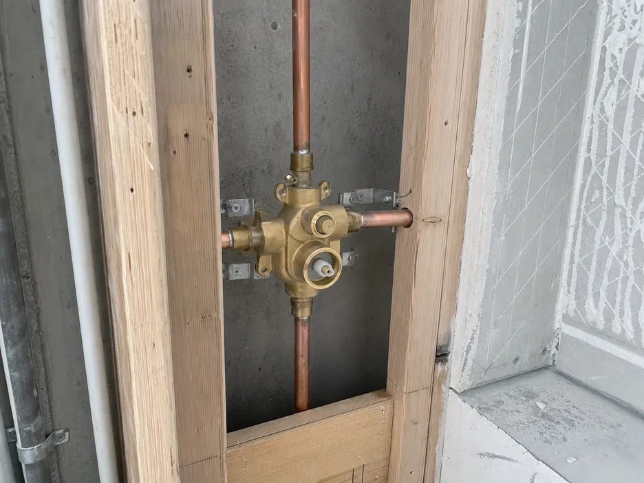 3-way concealed shower mixer rough-in valve body installation in wall cavity showing outlet port positions