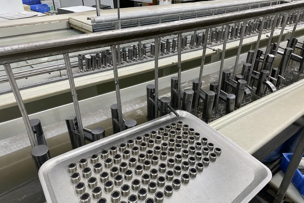 Aerator housings on the electroplating finishing line alongside faucet bodies for exact color matching