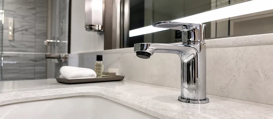 Hotel bathroom faucet with compliant low-flow aerator installed