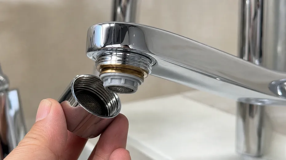 Brass housing detail of filter faucet aerator showing chrome finish and twist-off filter access