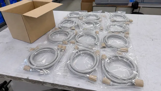 Supply hoses coiled and poly-bagged with cardboard end caps protecting fittings