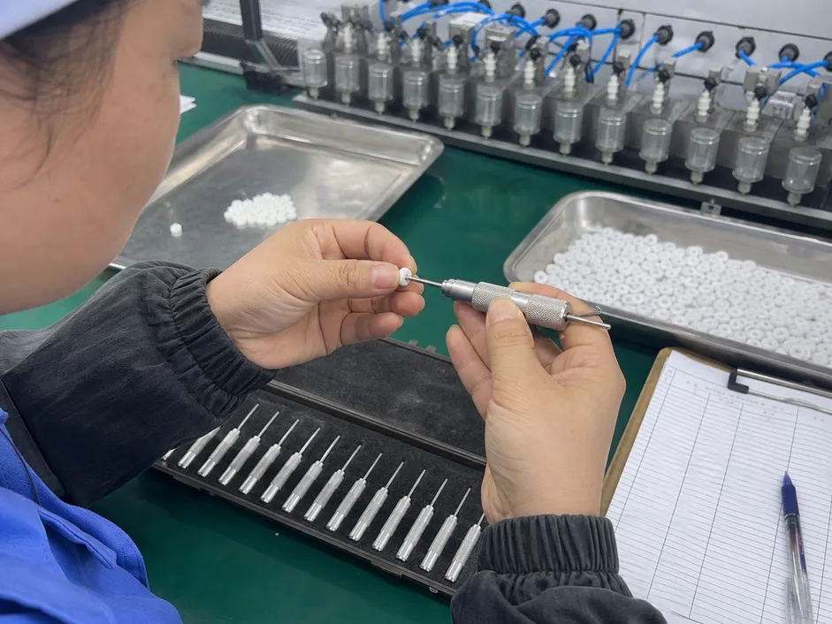 Flow restrictor disc with calibrated orifice undergoing pin gauge inspection at Wfaucet production facility