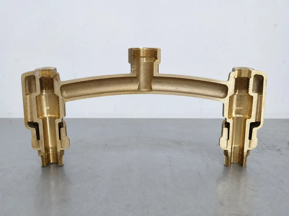 One-piece bridge casting cross-section showing single brass unit with arch, two supply risers, and spout mounting boss
