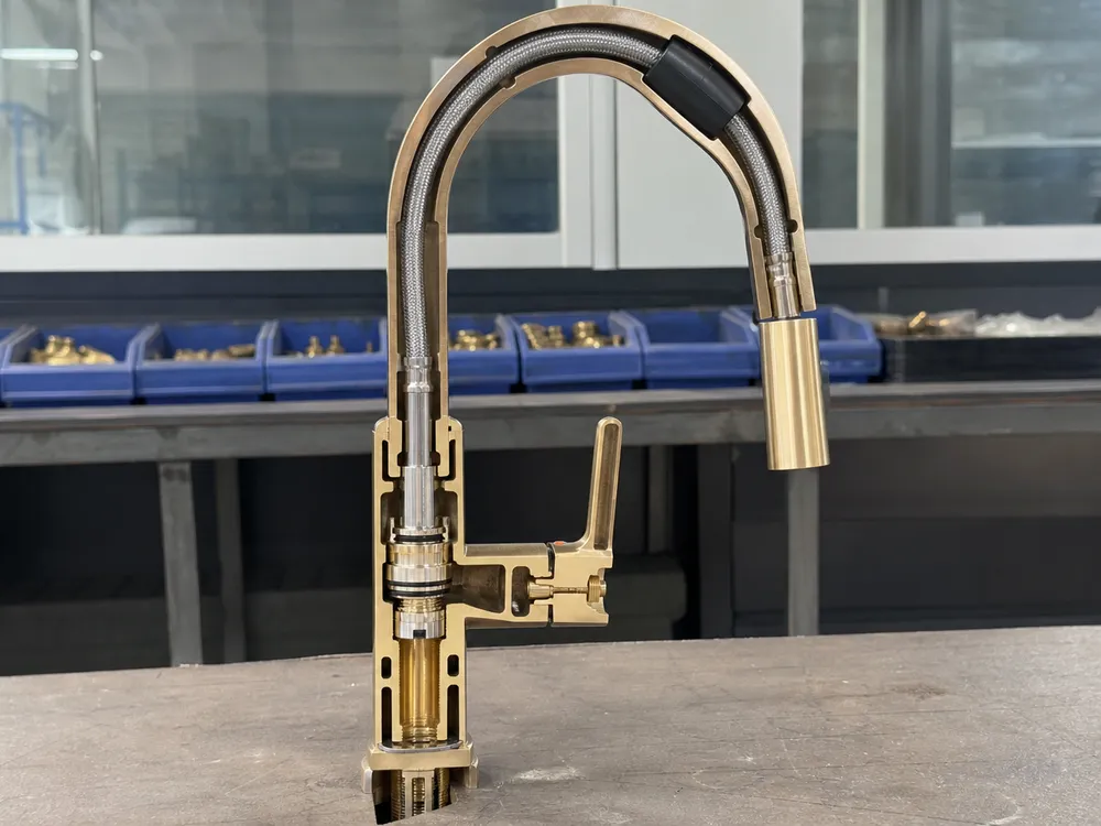 Gooseneck faucet brass body cross-section showing spout-to-body swivel joint and CNC machined valve seat