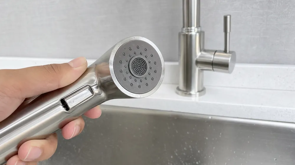 Kitchen faucet side sprayer with silicone nozzle face for hard-water markets