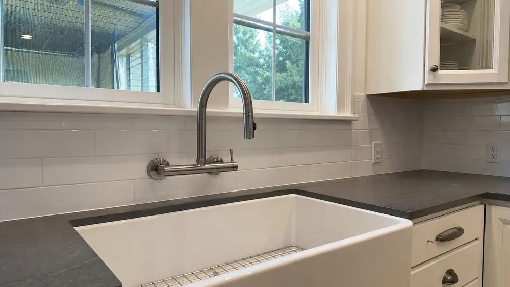 Wall mount kitchen faucet installed above farmhouse sink