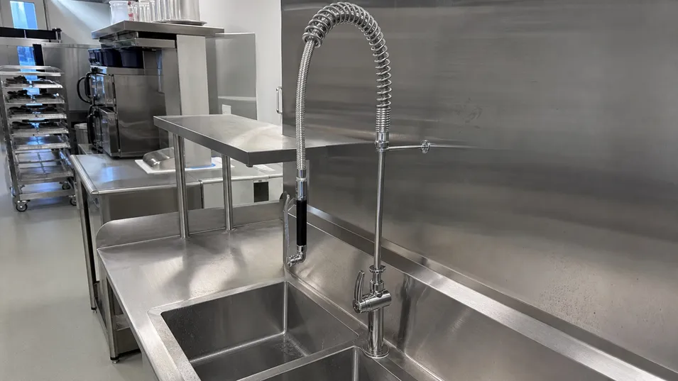 Stainless steel kitchen faucet installed in commercial food service kitchen