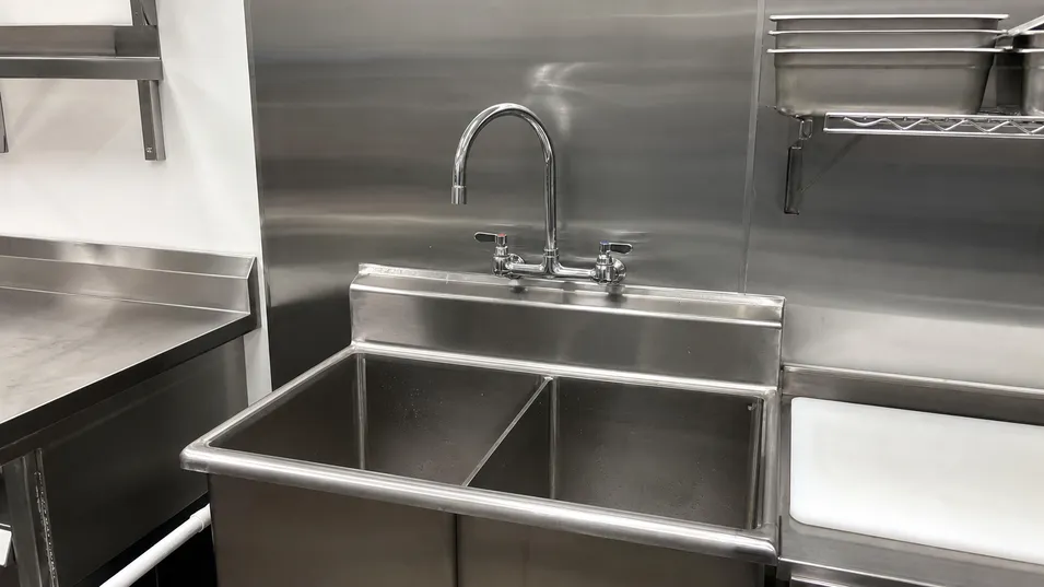 Commercial kitchen wall mount faucet with gooseneck spout in food service installation