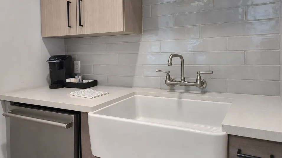 Wall mount faucet in hotel kitchen or serviced apartment compact kitchen configuration