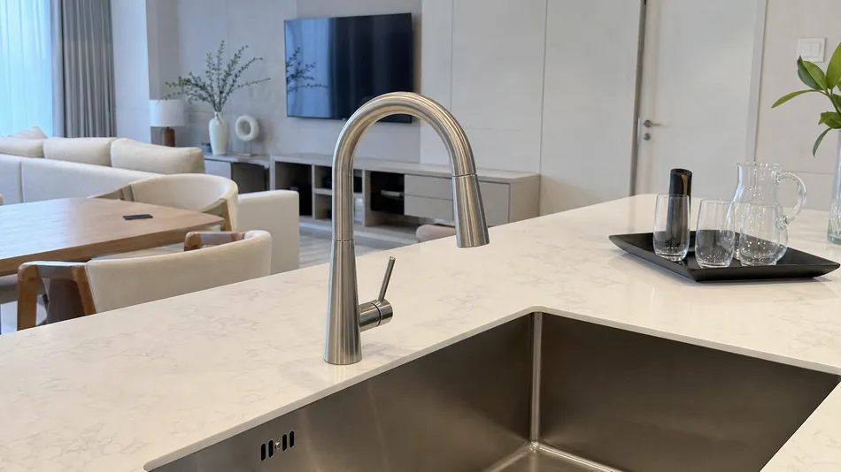 Premium hotel serviced apartment kitchen fit-out with waterfall faucet in brushed nickel finish