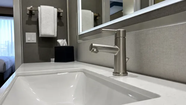 Brushed nickel faucet in a hotel bathroom