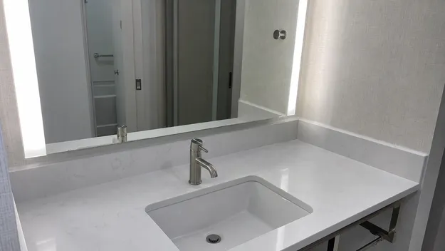 Brushed nickel faucet in hospitality hotel bathroom renovation