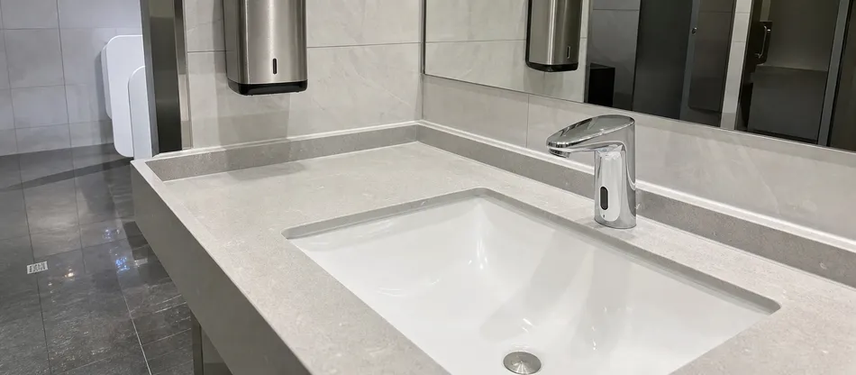 Corporate office washroom with sensor faucet as part of sustainability program