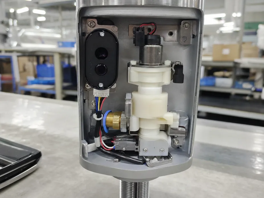 Close-up of IR sensor module and solenoid valve assembly in a commercial sensor faucet