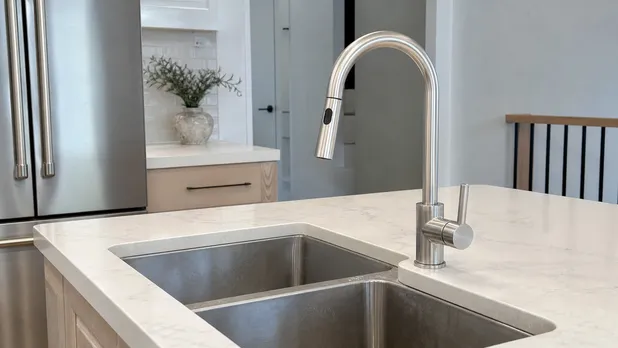 Brushed stainless sink faucet paired with a stainless steel sink in a contemporary residential kitchen