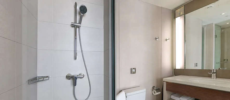 Commercial hotel bathroom with consistent shower faucet specification across multiple units