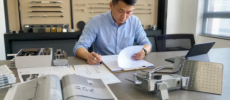 Plumbing contractor reviewing shower faucet specification documentation for multi-unit project