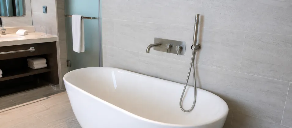Hotel suite bathroom with wall mount bathtub faucet in hospitality renovation project