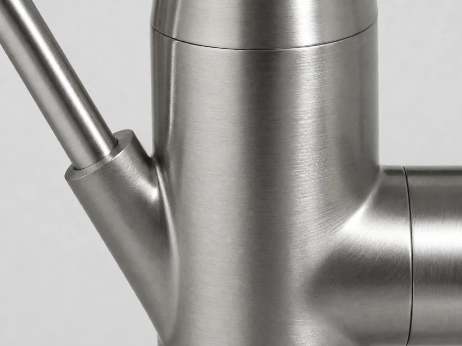 Close-up of brushed nickel finish on water filter faucet body showing directional grain texture