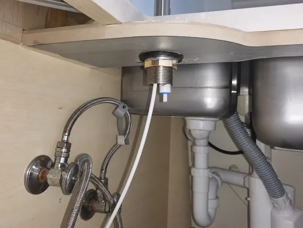 RO faucet installation under sink showing supply tube routing and deck hole connection