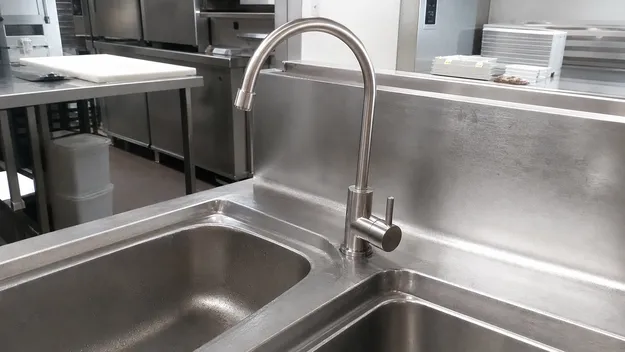 Stainless steel water filter faucet installed in a commercial kitchen prep station
